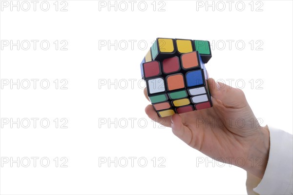 Child holding a Rubik's cube in hand on a white background