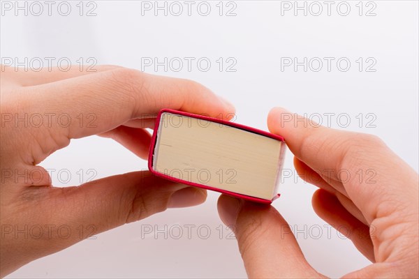 Hand holding The Holy Quran on a white background