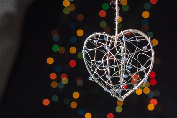 Heart shaped metal cage on a bokeh light background