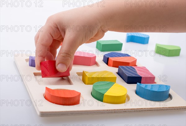 Colorful wooden pieces of a logic puzzle in hand