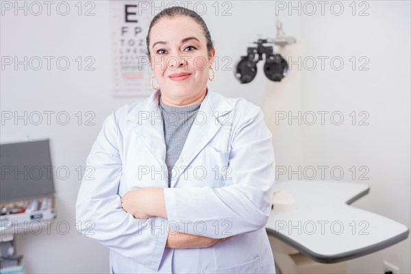 Portrait of female optometrist with arms crossed in the laboratory. Smiling female oculist with arms crossed in office