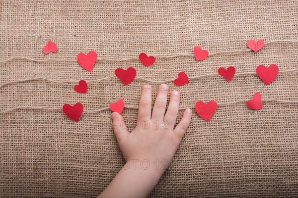 Love concept with heart shaped papers on linen threads