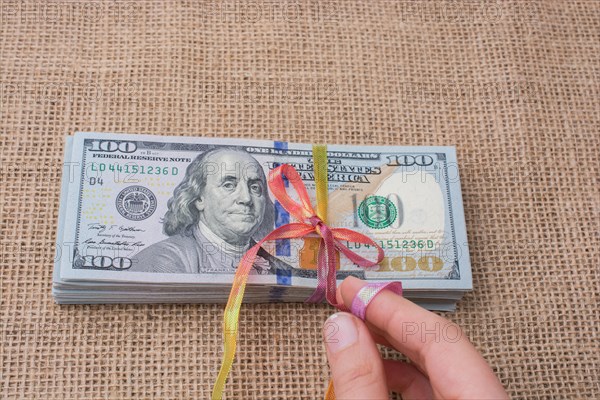 Banknote bundle of US dollar tied with colorful a ribbon