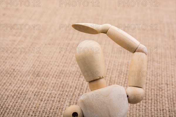 Wooden dolls of a man posing on canvas