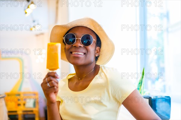 Portrait of black African ethnicity woman eating a mango ice cream in a store