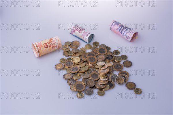 Turkish Lira coins and banknotes side by side on white background