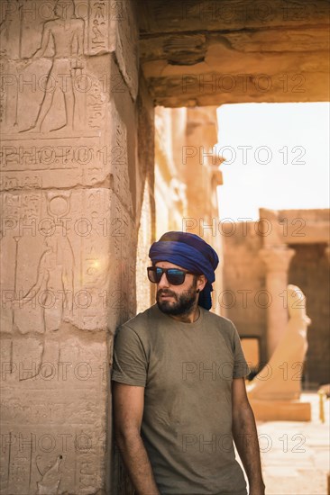 Portrait of a young man with a blue turban at the entrance to the Edfu Temple near the city of Aswan. Egypt