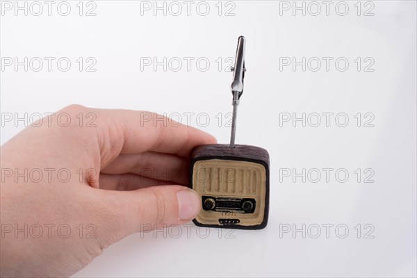 Hand holding a retro TV model on a white background