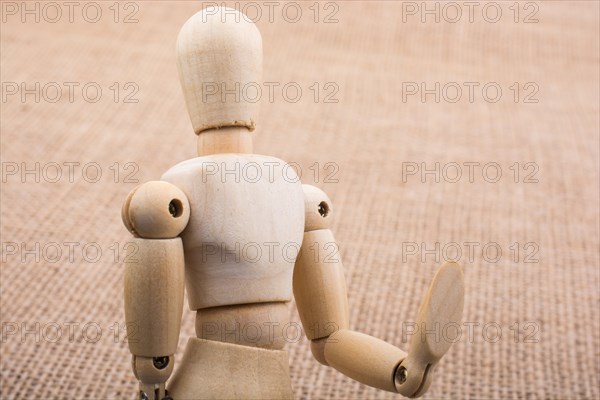 Wooden dolls of a man posing on canvas