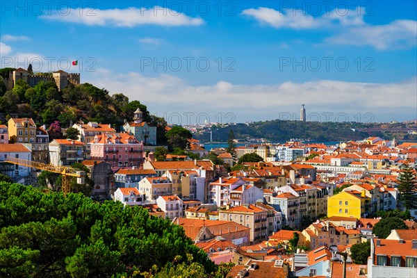 Lisbon famous view from Miradouro dos Barros tourist viewpoint over Alfama old city district with St. George's Castle and Portugal flag