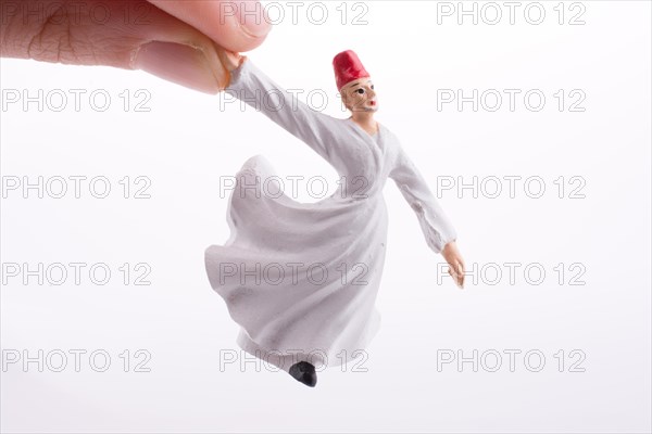 Hand holding a Sufi Dervis on a white background