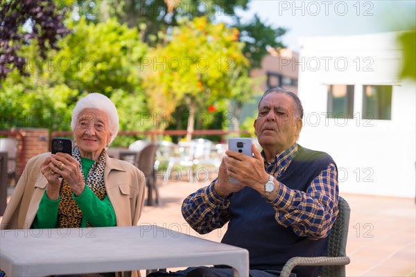 Two very happy elderly people in the garden of a nursing home