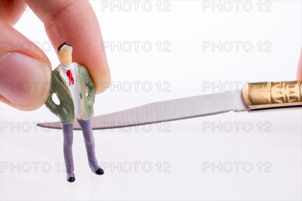 Hand holding a pocket knife near a human figure on a white background