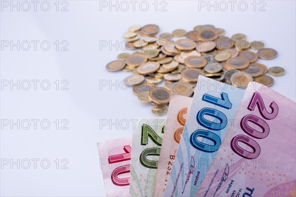 Turkish Lira coins and banknotes side by side on white background