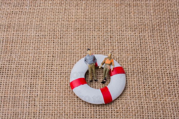 Little figurine men in a life preserver on life on canvas
