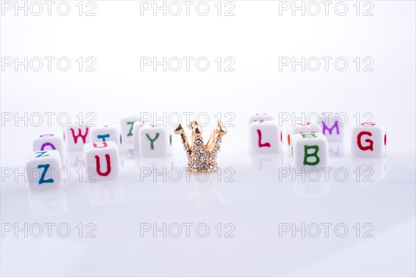Crown between Letter cubes on a white background