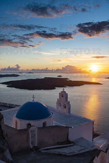 Sunset over the volcanic islands of Santorini and Anastasi Orthodox Church at sunset