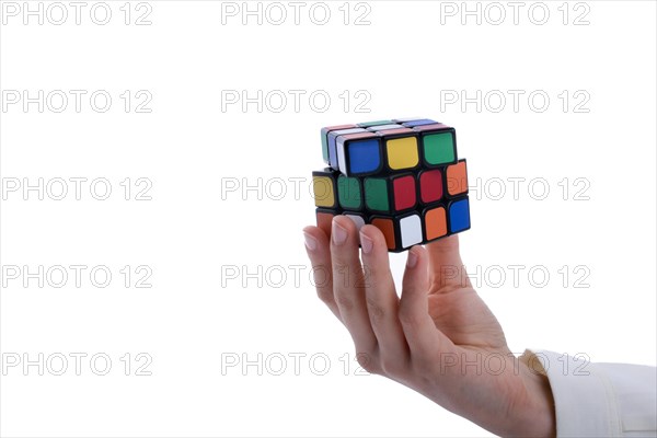 Child holding a Rubik's cube in hand on a white background