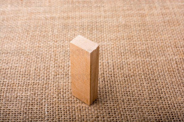 Wooden domino on a linen canvas background