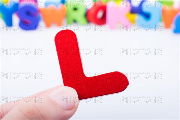 Hand holding letter cube L of made of wood