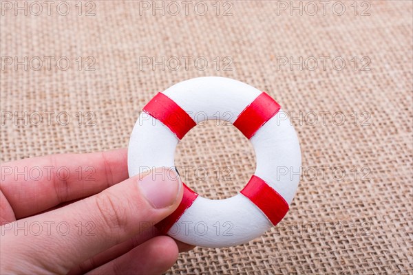 Life preserver in hand on canvas canvas background