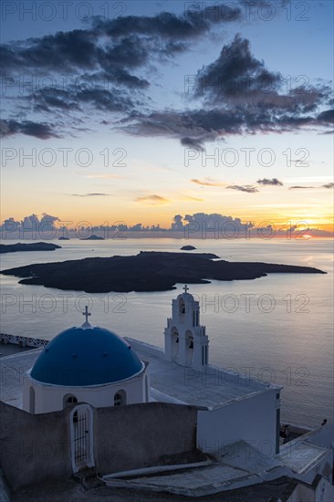 Sunset over the volcanic islands of Santorini and Anastasi Orthodox Church at sunset