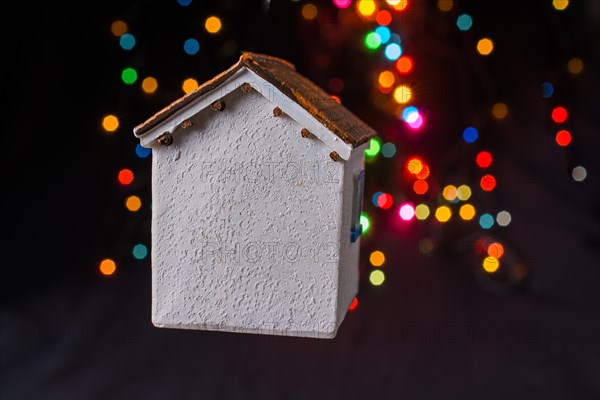 Little model house on a bokeh ligh ton a dark background