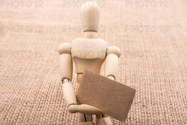 Wooden dolls posing with a noticeboard on canvas