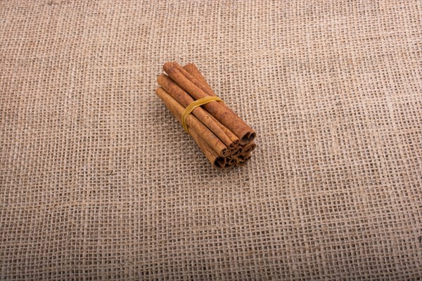 Bundle of cinnamon sticks on a linen canvas background