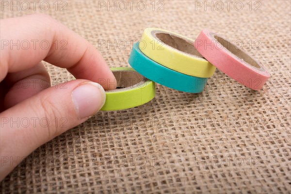 Colorful insulating adhesive tapes on linen canvas background