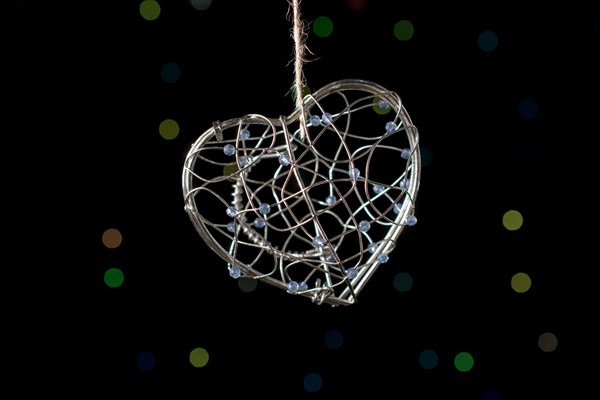 Heart shaped metal cage on a bokeh light background