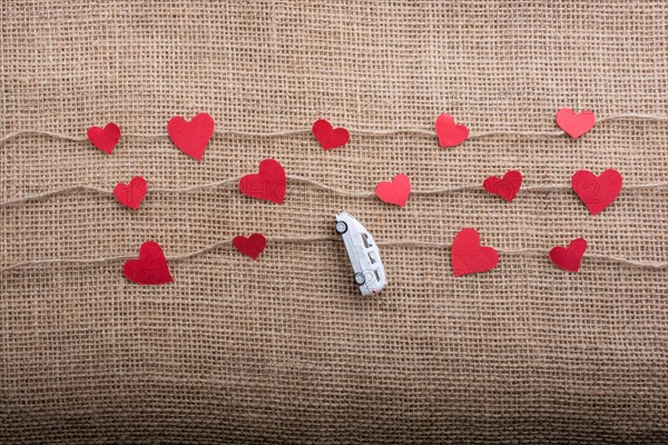 Love concept with car and paper heart on linen threads