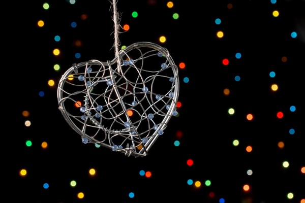 Heart shaped metal cage on a bokeh light background