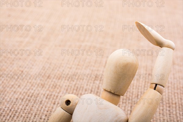 Wooden dolls of a man posing on canvas