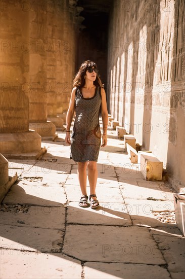 Portrait of a young brunette on the columns of the Edfu Temple near the city of Aswan. Egypt