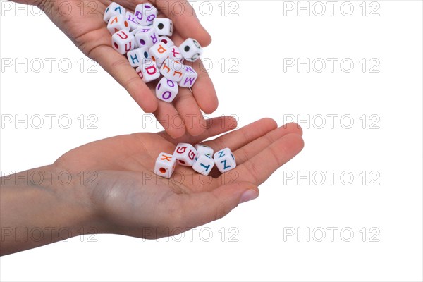 Hand holding colorful alphabet letters as cubes on white background