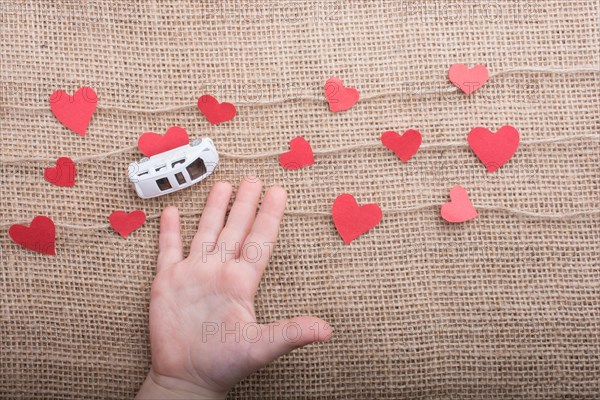 Love concept with car and paper heart on linen threads