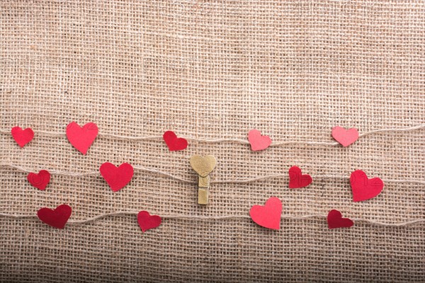 Love concept with heart shaped papers on linen threads