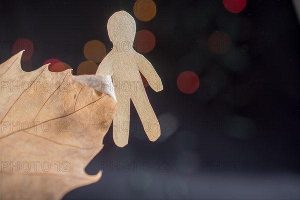 Paper man shape in hand on bokeh light background