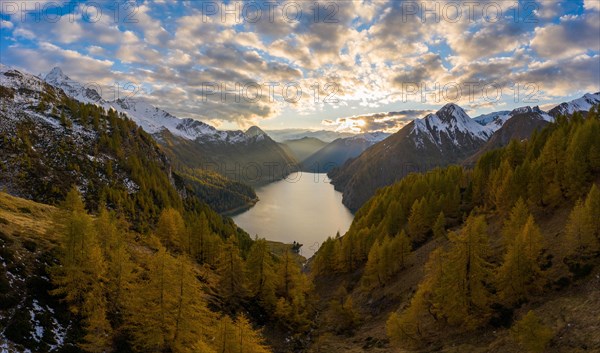 Aerial view at sunset over the autumnal forest at Lago di Luzzone in Valle di Blenio