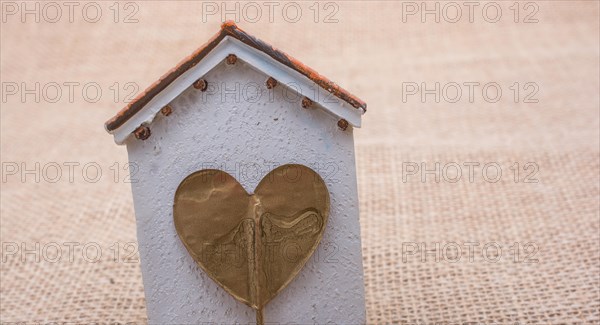 Heart shape icon placed on a little model house