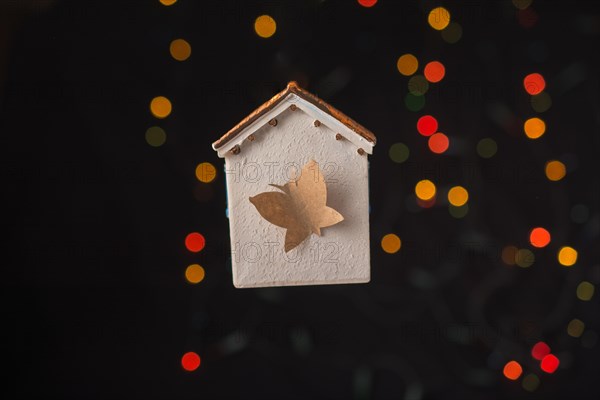 Paper butterfly on a Model house on a bokeh light