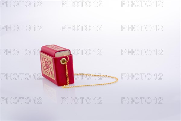 Hand holding The Holy Quran on a white background