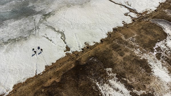 Aerial of fisherman walking on lake Tengiz