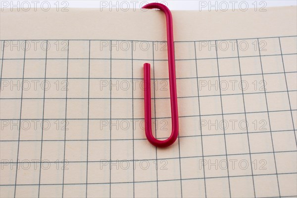 Colored paper clip on a checked notebook page