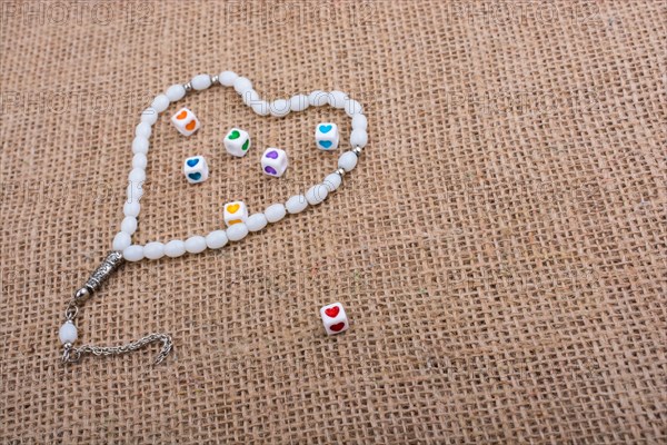 Heart shaped cubes in hand by inside a praying beads