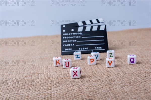 Colorful letter cubes beside a director clapper board
