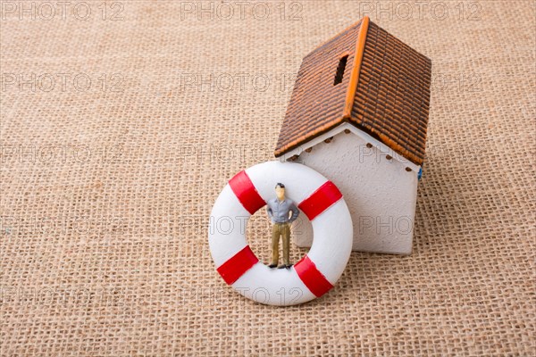 Model house and a life preserver with a man figure on it