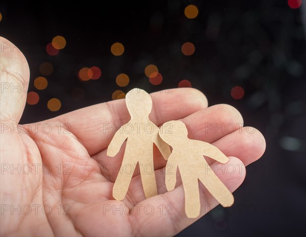 Paper man shape in hand on bokeh light background