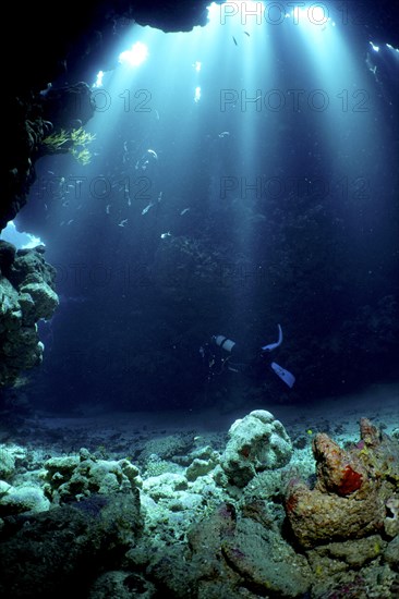 Diver swimming in cave